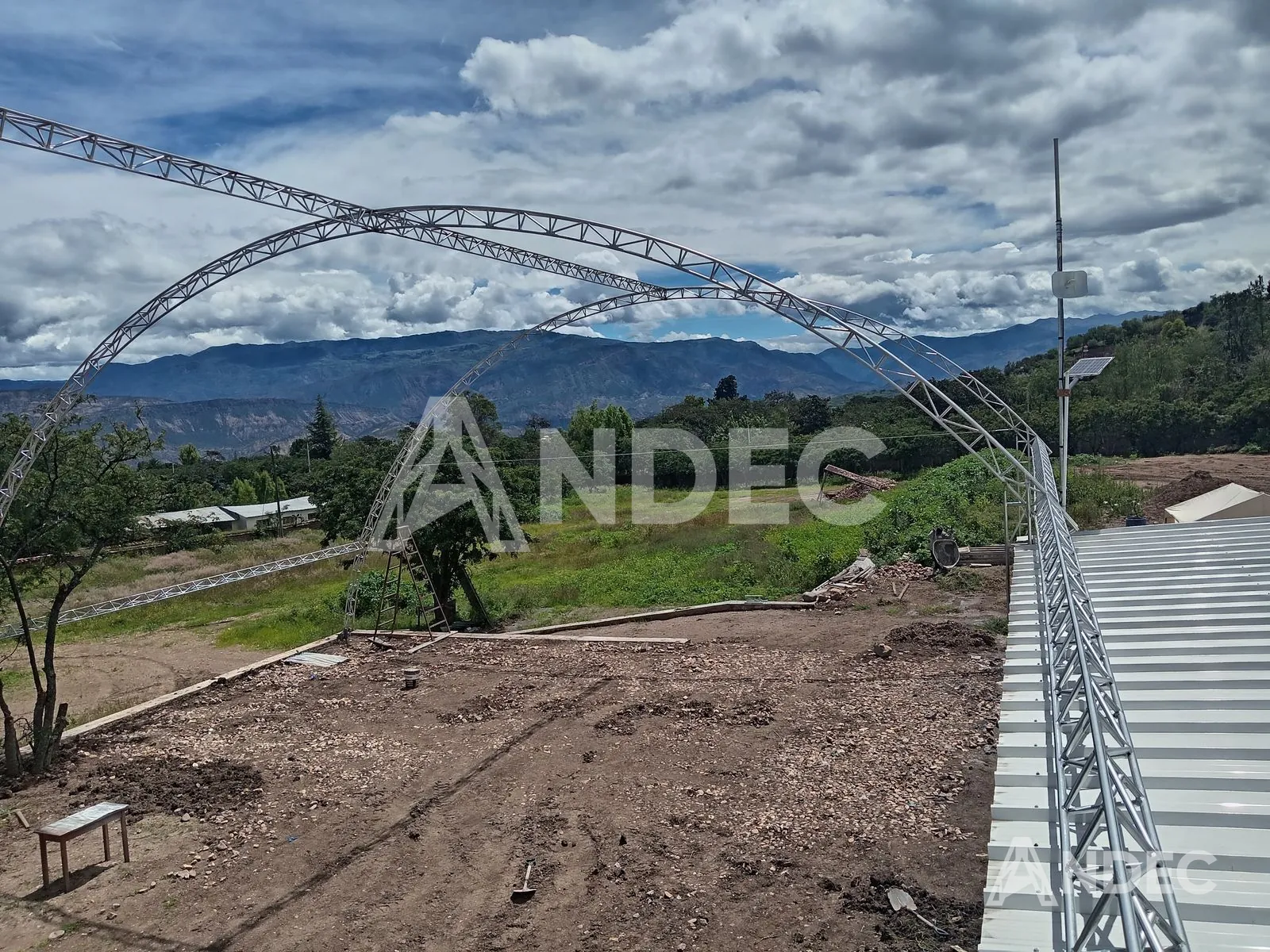 Estructura de arcos reticulados vista desde un extremo, con el valle de Huanta al fondo