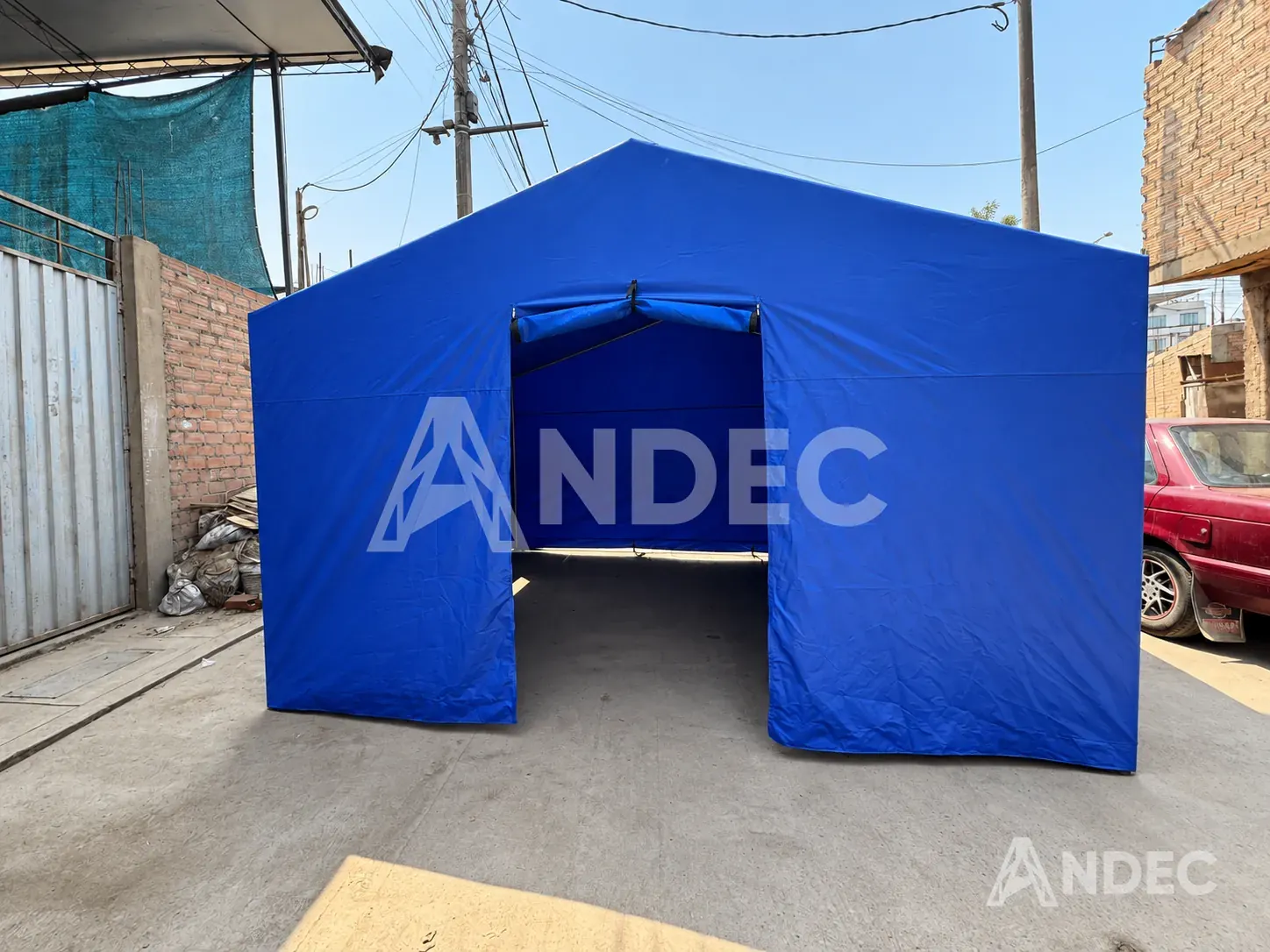 Frente de una carpa dos aguas azul con la puerta enrollada