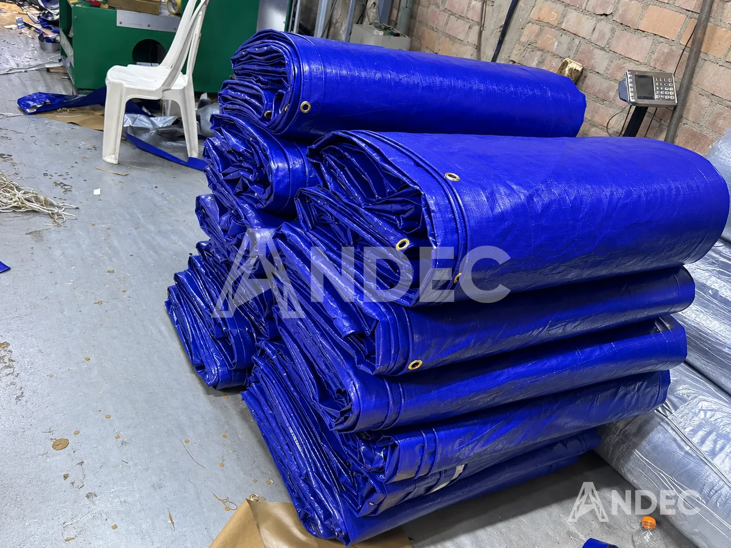 Lote de mantas de tarflex azul de 200 gr/m² plegadas en la planta de ANDEC