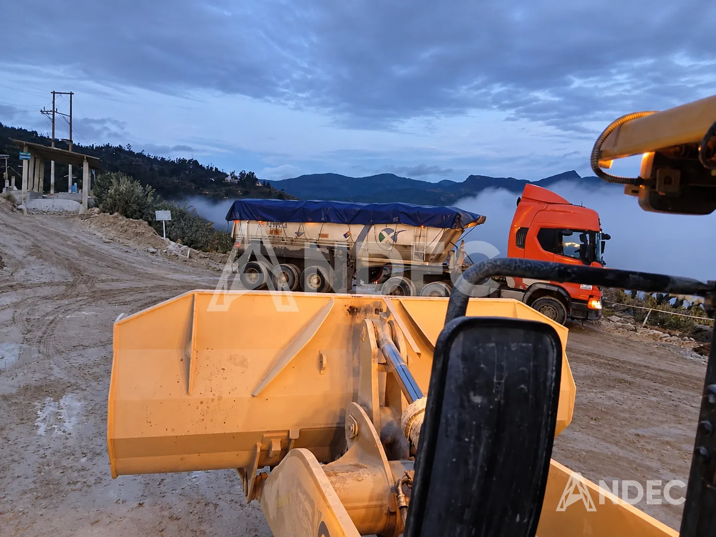 Toldera de lona azul cubriendo la tolva de un semirremolque volquete en una operación minera