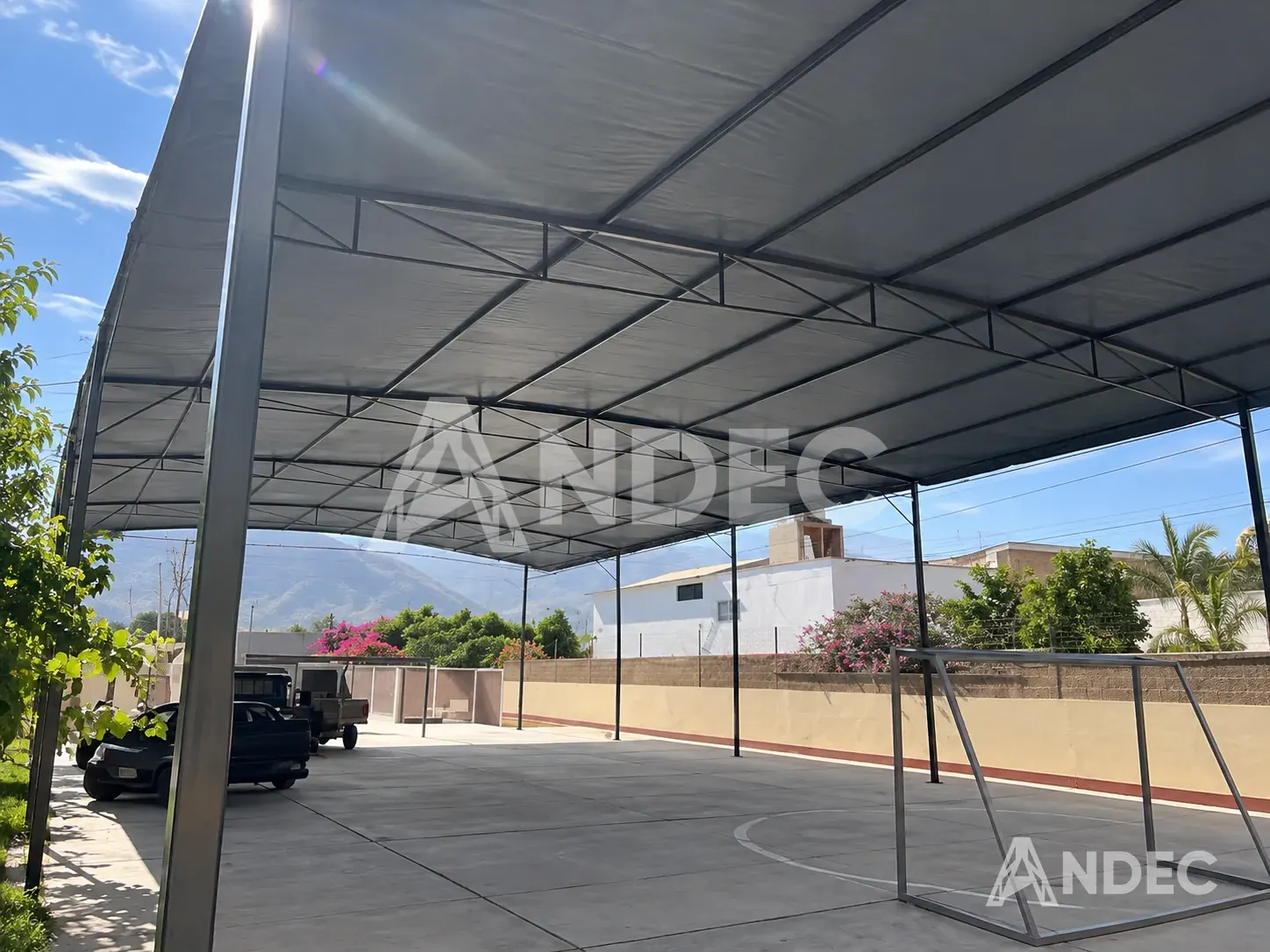 Cobertura de cancha deportiva en lona PVC gris tensada sobre estructura metálica